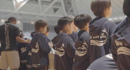 小学生がプロ選手と手をつなぎ、小田原アリーナのピッ